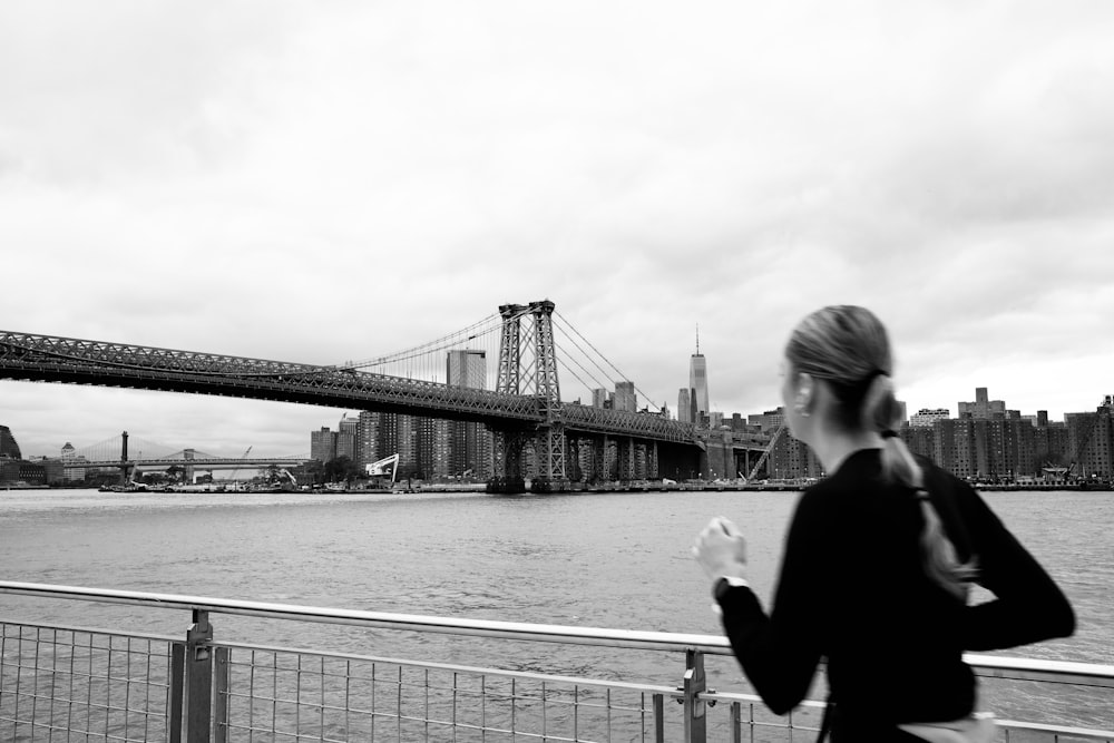 a woman running on a bridge over a body of water