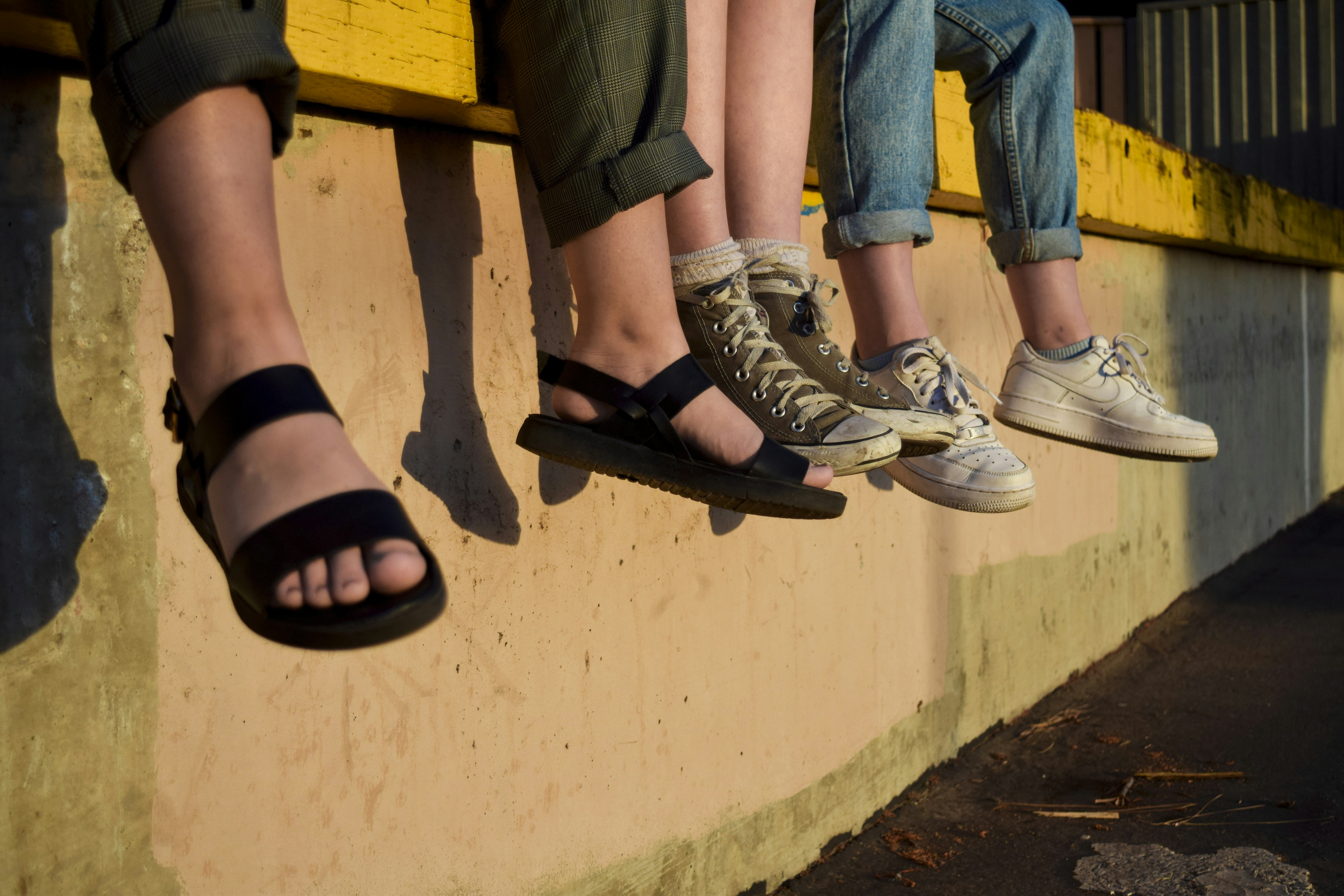 un groupe de personnes assises au sommet d’un mur jaune