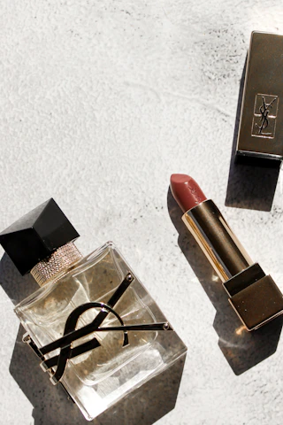a lipstick and a pair of scissors on a table