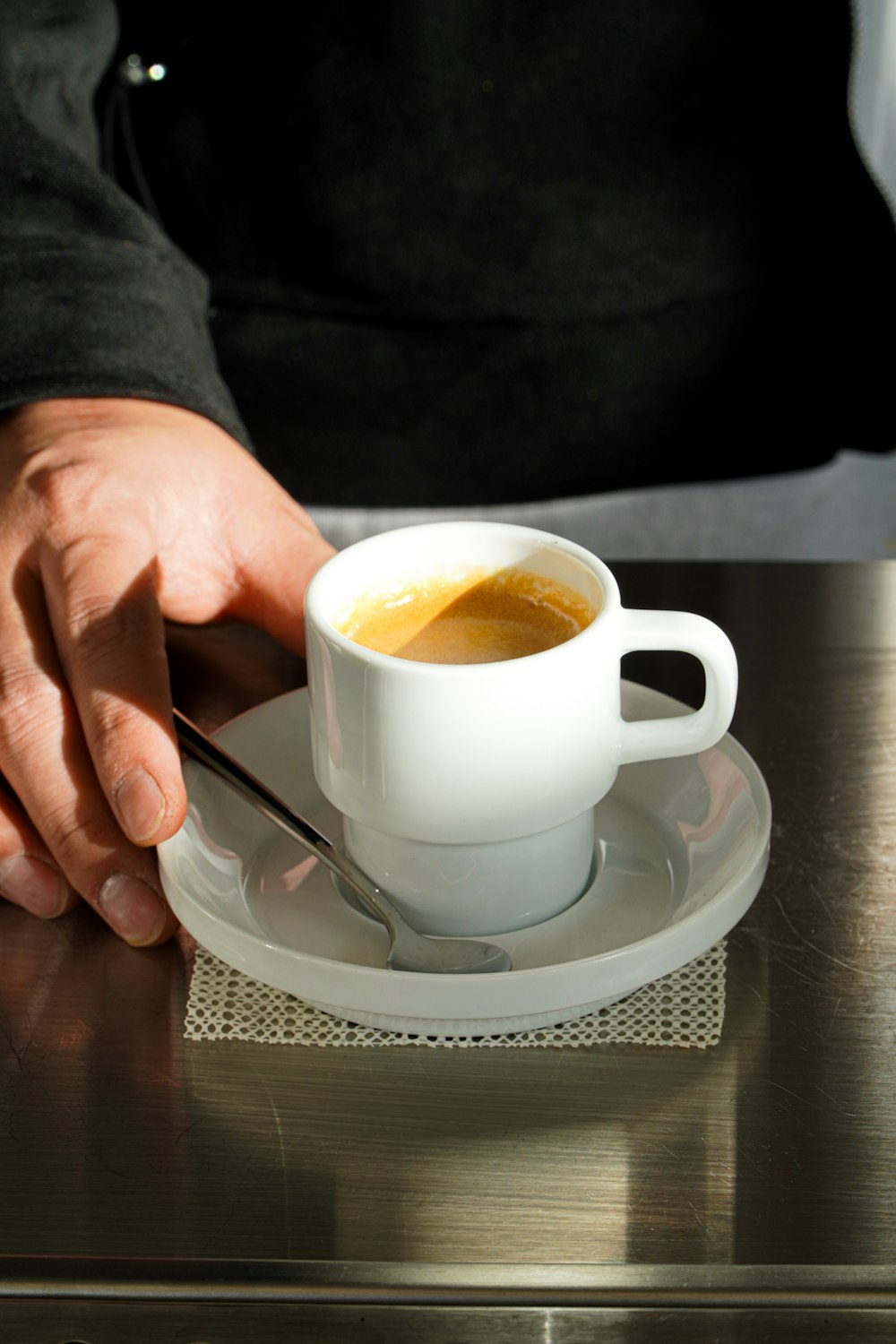 a cup of coffee on a saucer with a spoon