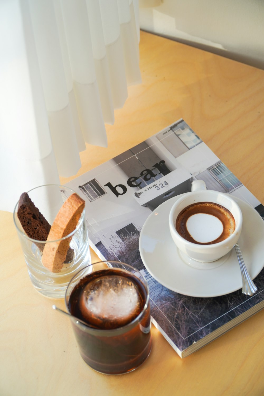 a cup of coffee on a table next to a newspaper