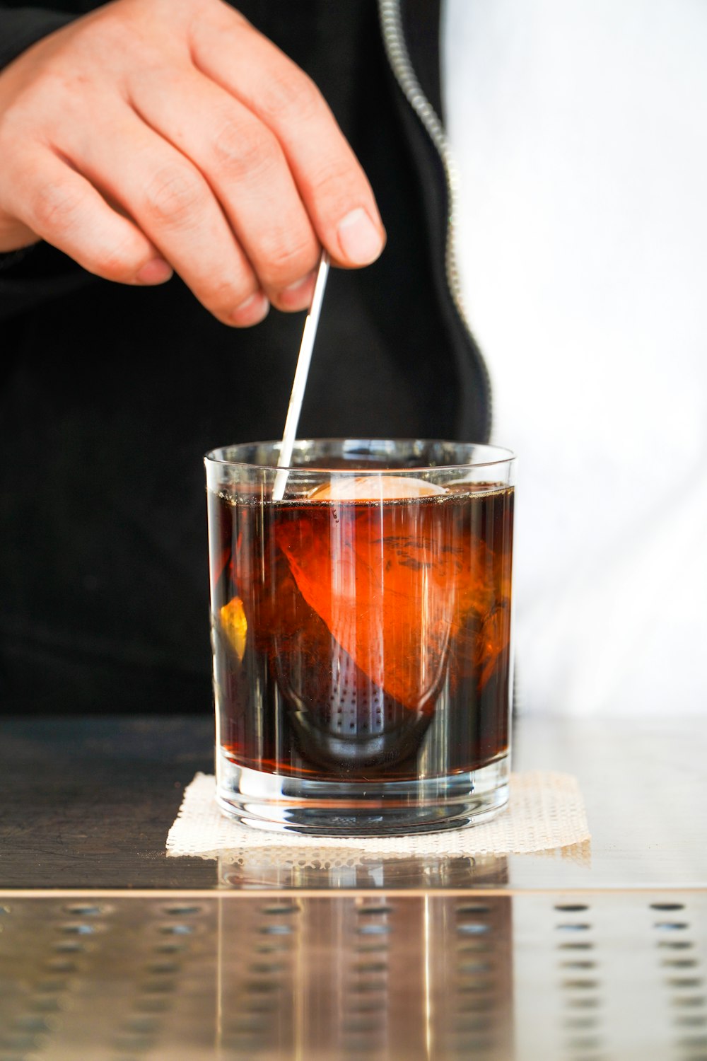 a person is holding a spoon in a glass