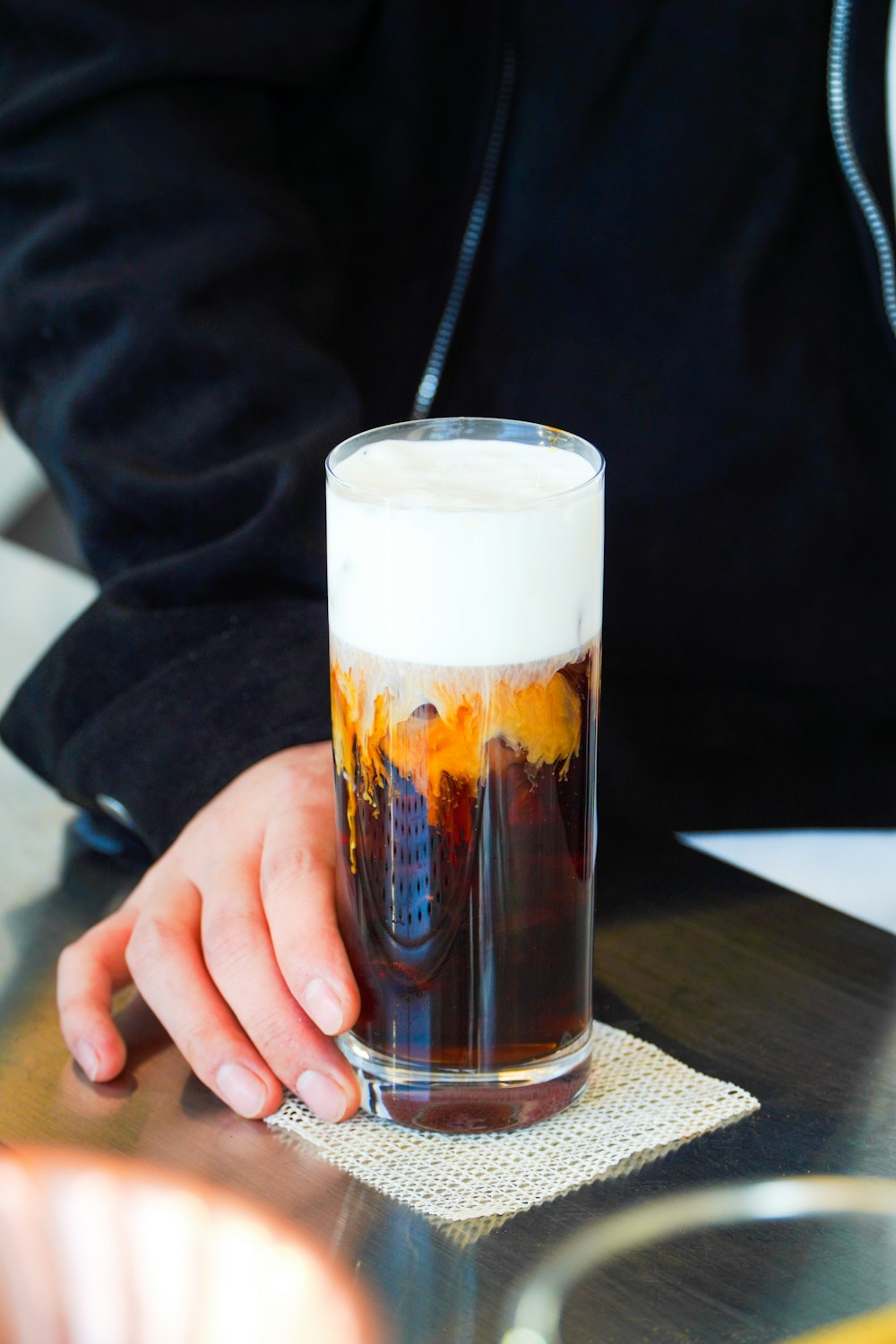 a person sitting at a table with a glass of beer