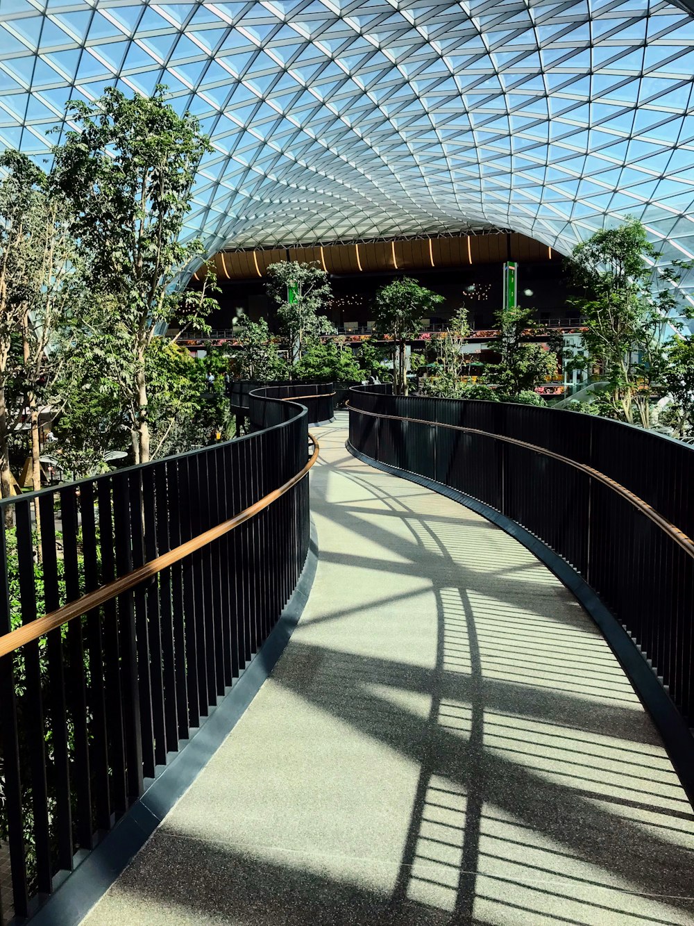 a walkway inside a building with a glass roof