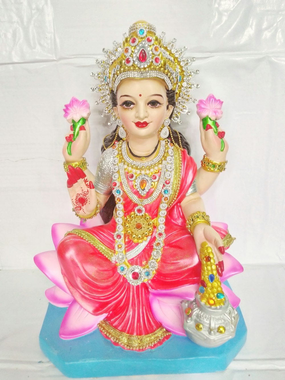 a statue of a woman sitting on top of a blue base