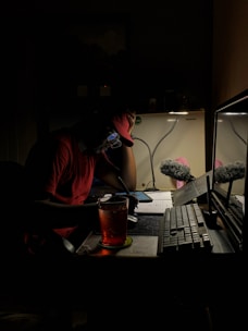 a man sitting in front of a computer in the dark