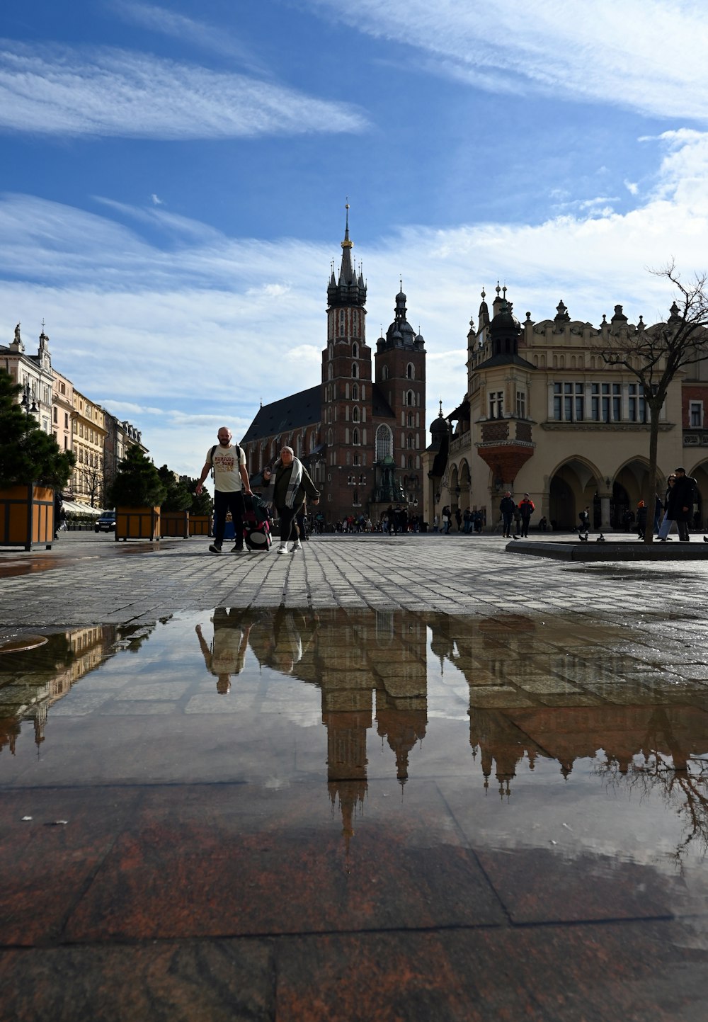 a reflection of a clock tower in a puddle of water