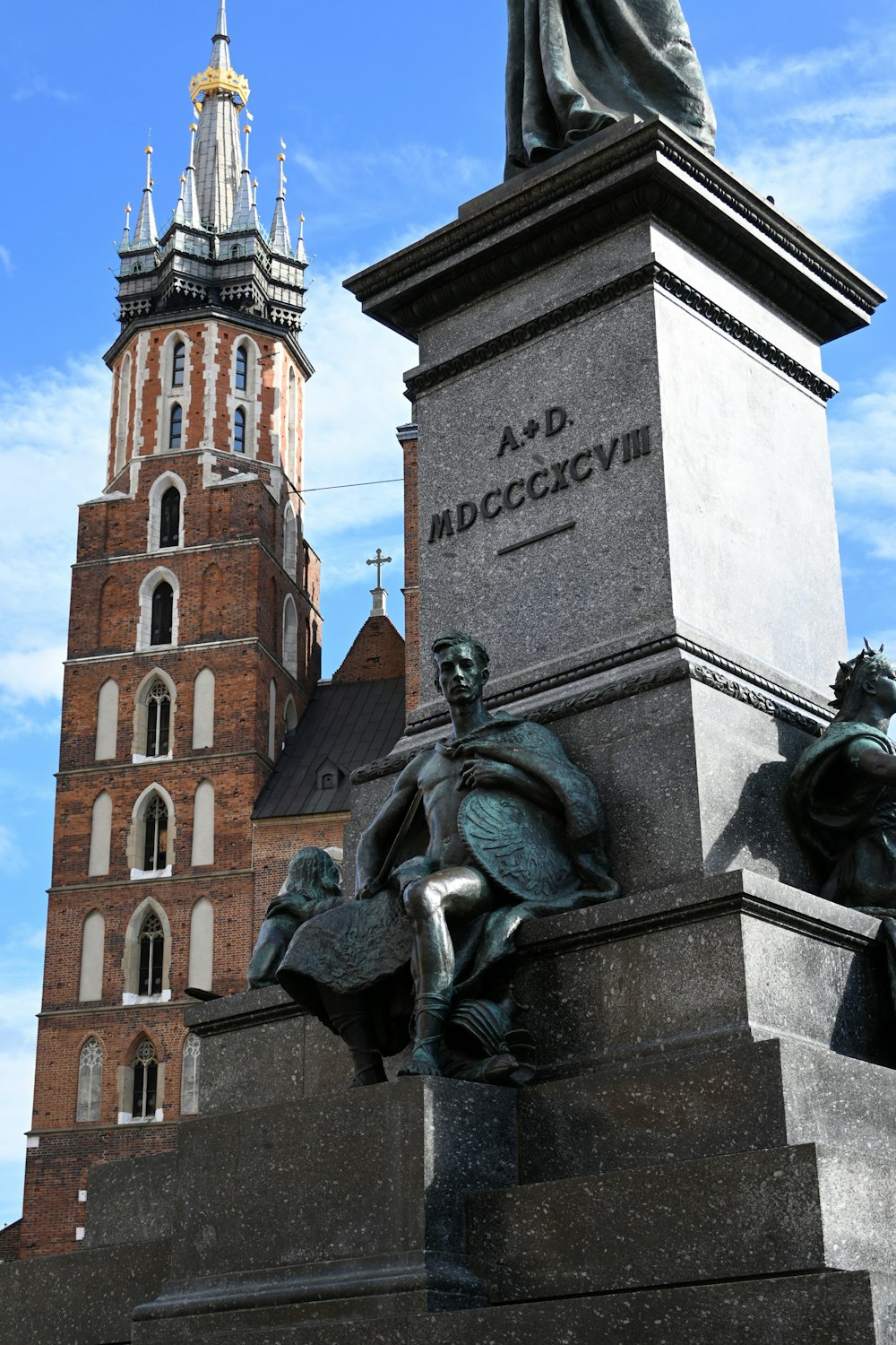 une statue devant un grand bâtiment avec une tour d’horloge