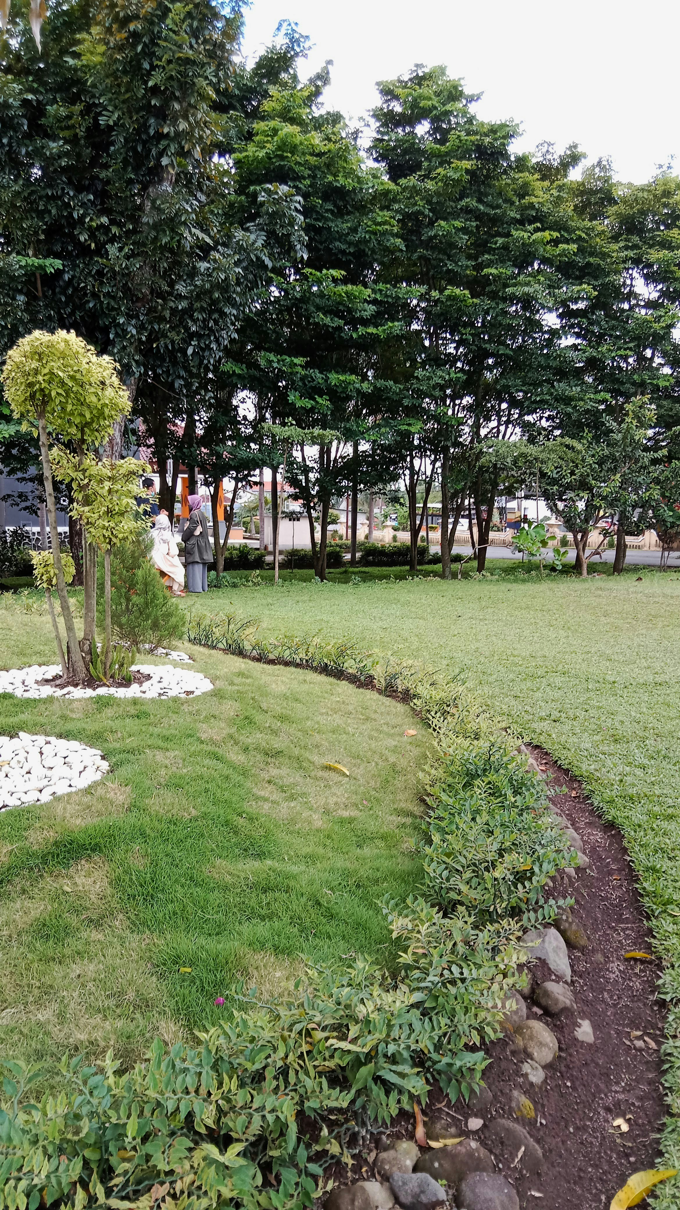 Beberapa orang berdiri di lapangan berumput