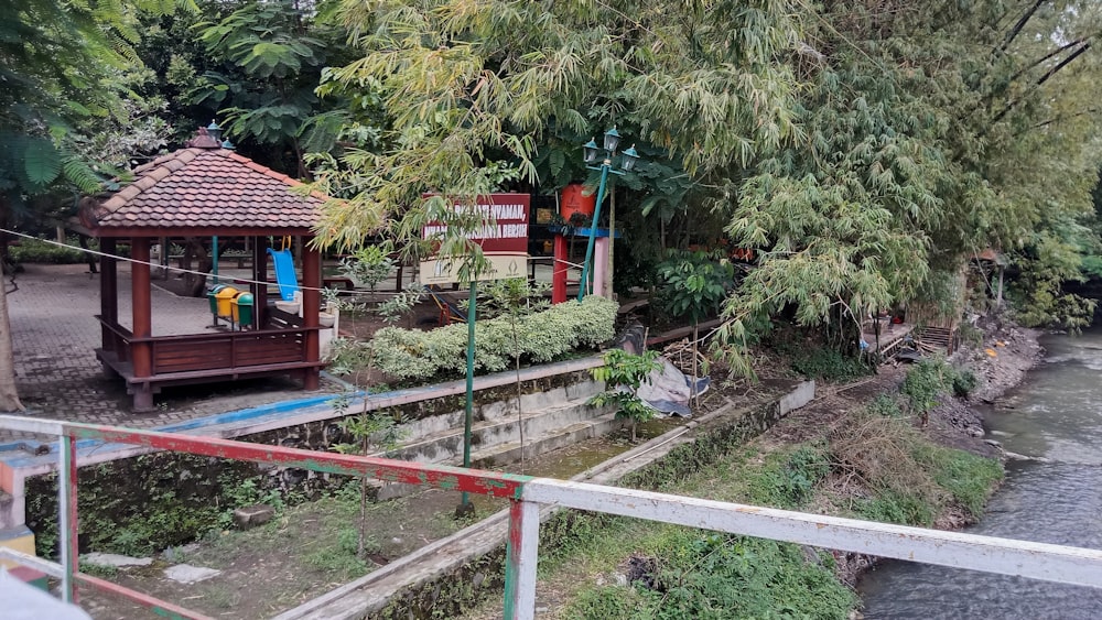 un piccolo gazebo di legno seduto vicino a un fiume