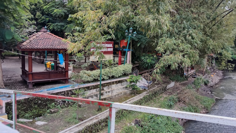 ein kleiner hölzerner Pavillon neben einem Fluss