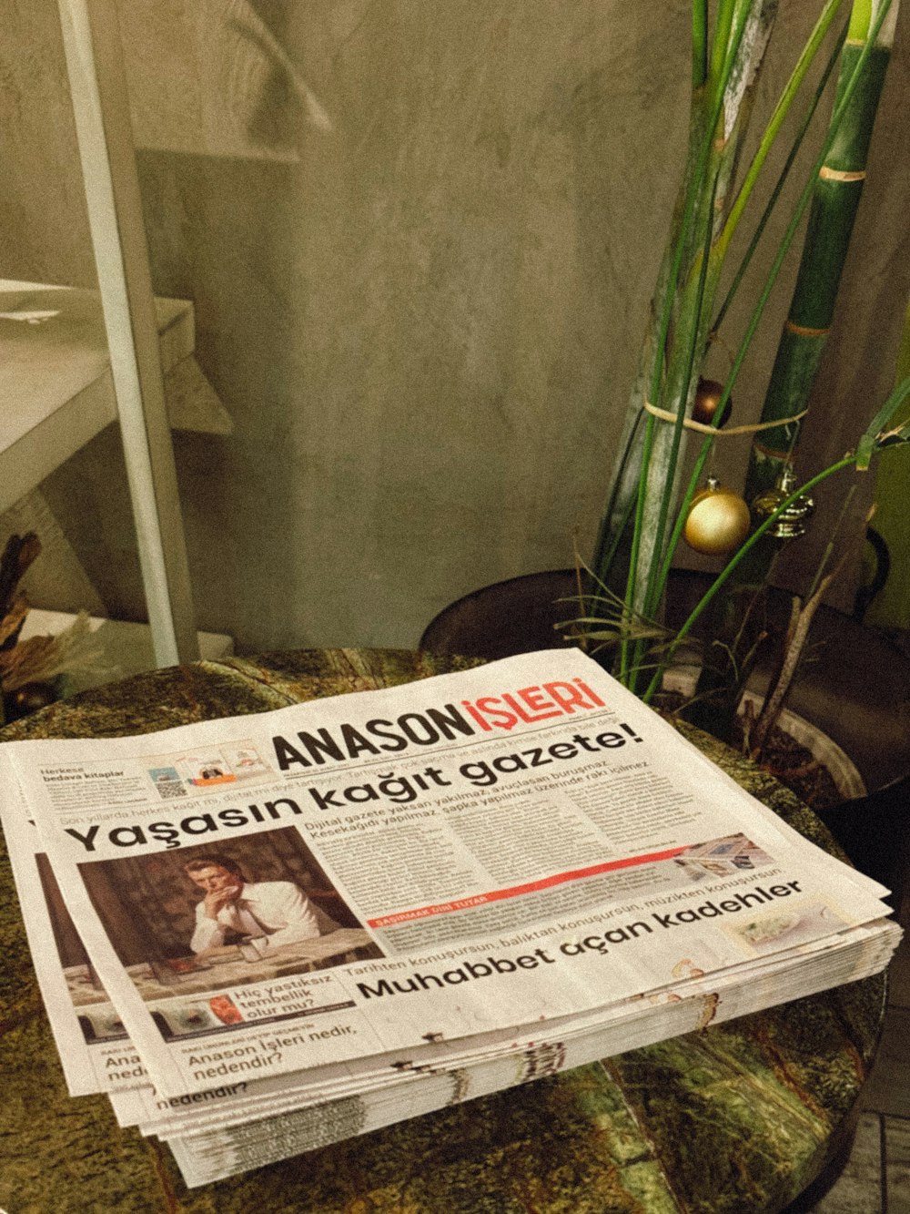 a stack of newspapers sitting on top of a table