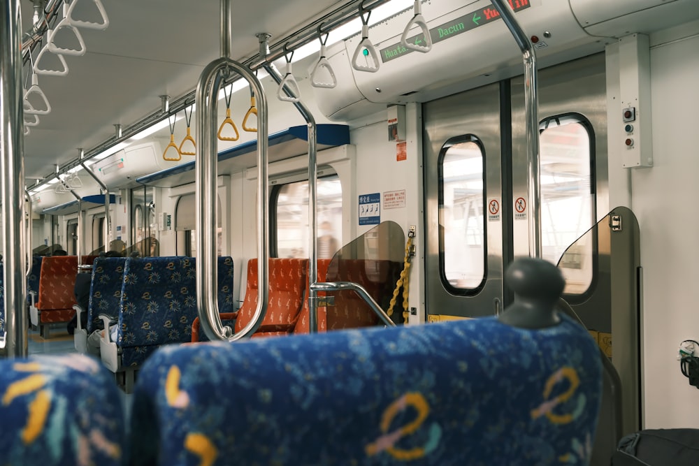 a train car with blue seats and yellow handles