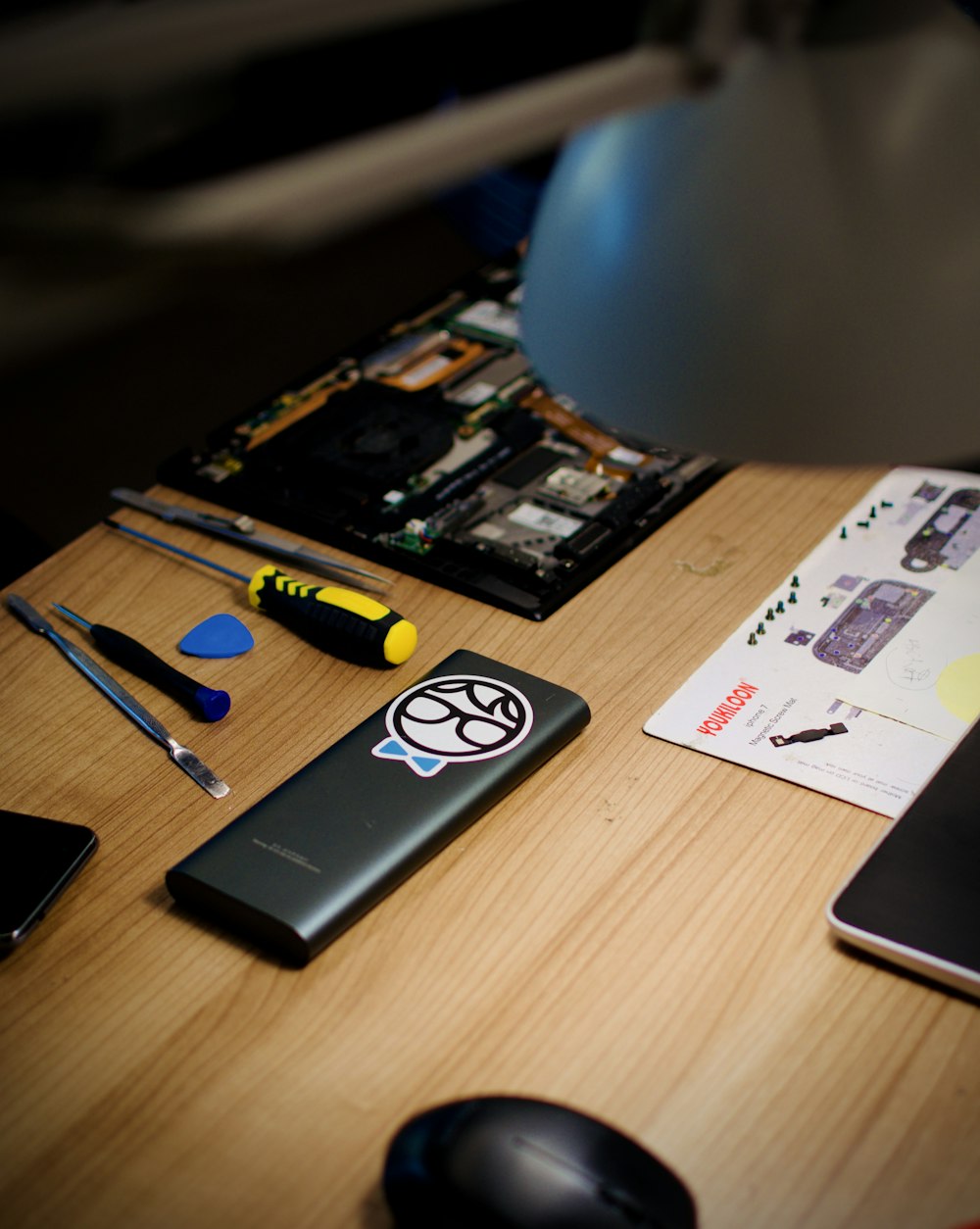 a desk with a laptop, mouse, and other items on it