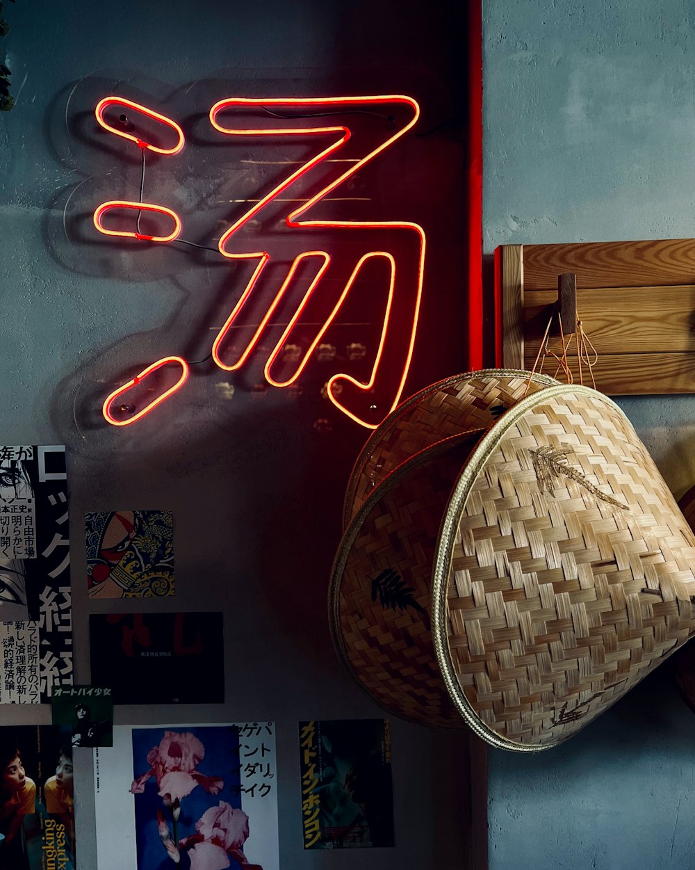 a wall with a neon sign and a hat hanging on it