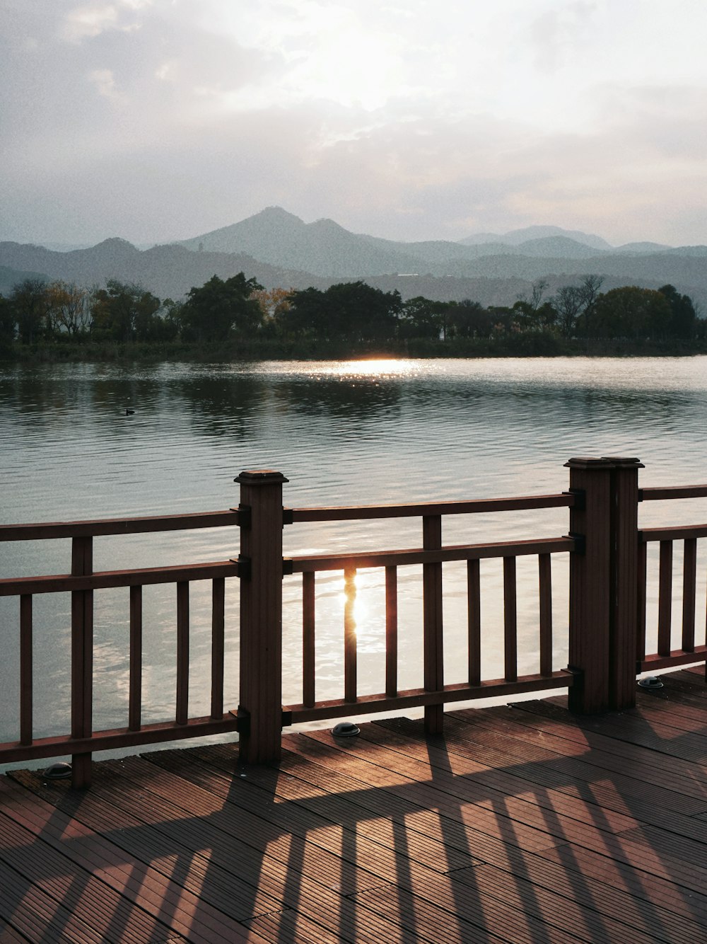 the sun is setting over the water on the pier