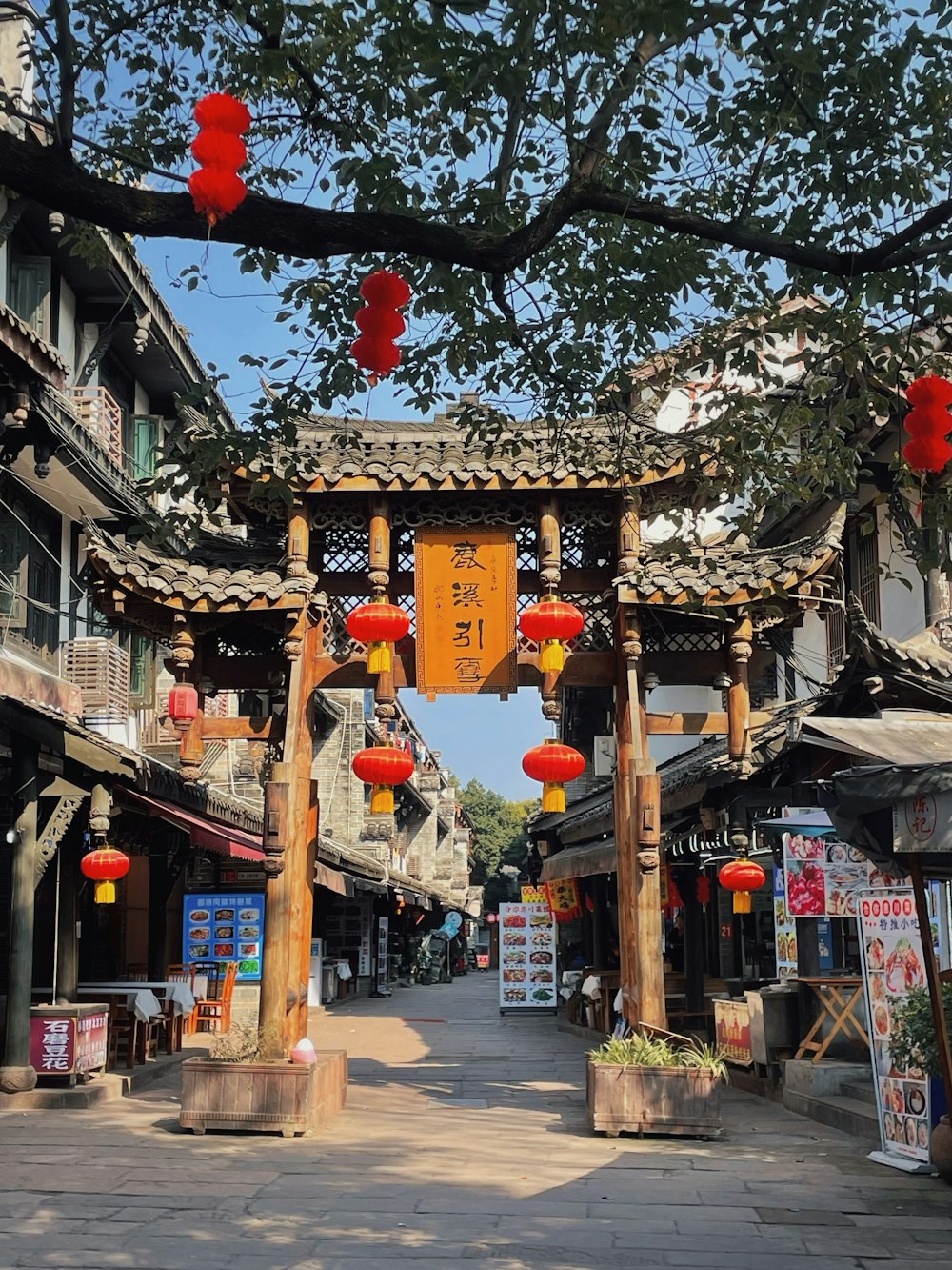 a street lined with lots of buildings with red lanterns hanging from them