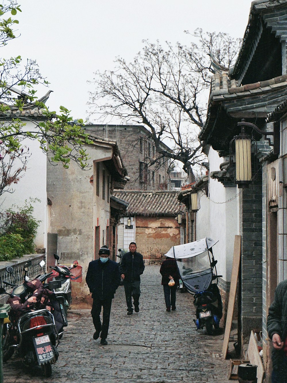 a group of people walking down a cobblestone street