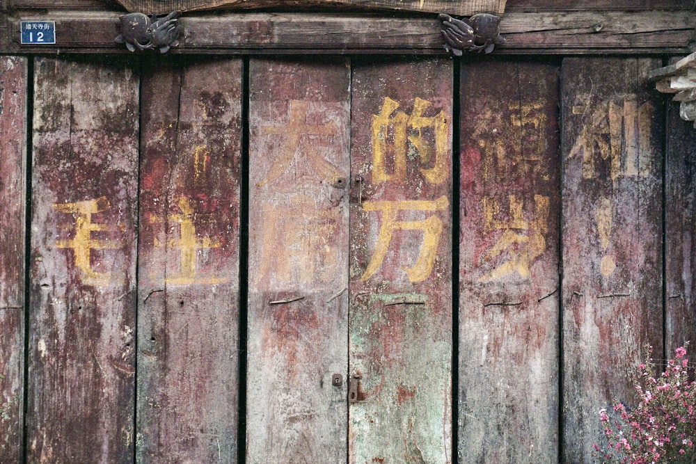 una staccionata di legno con dei graffiti scritti sopra
