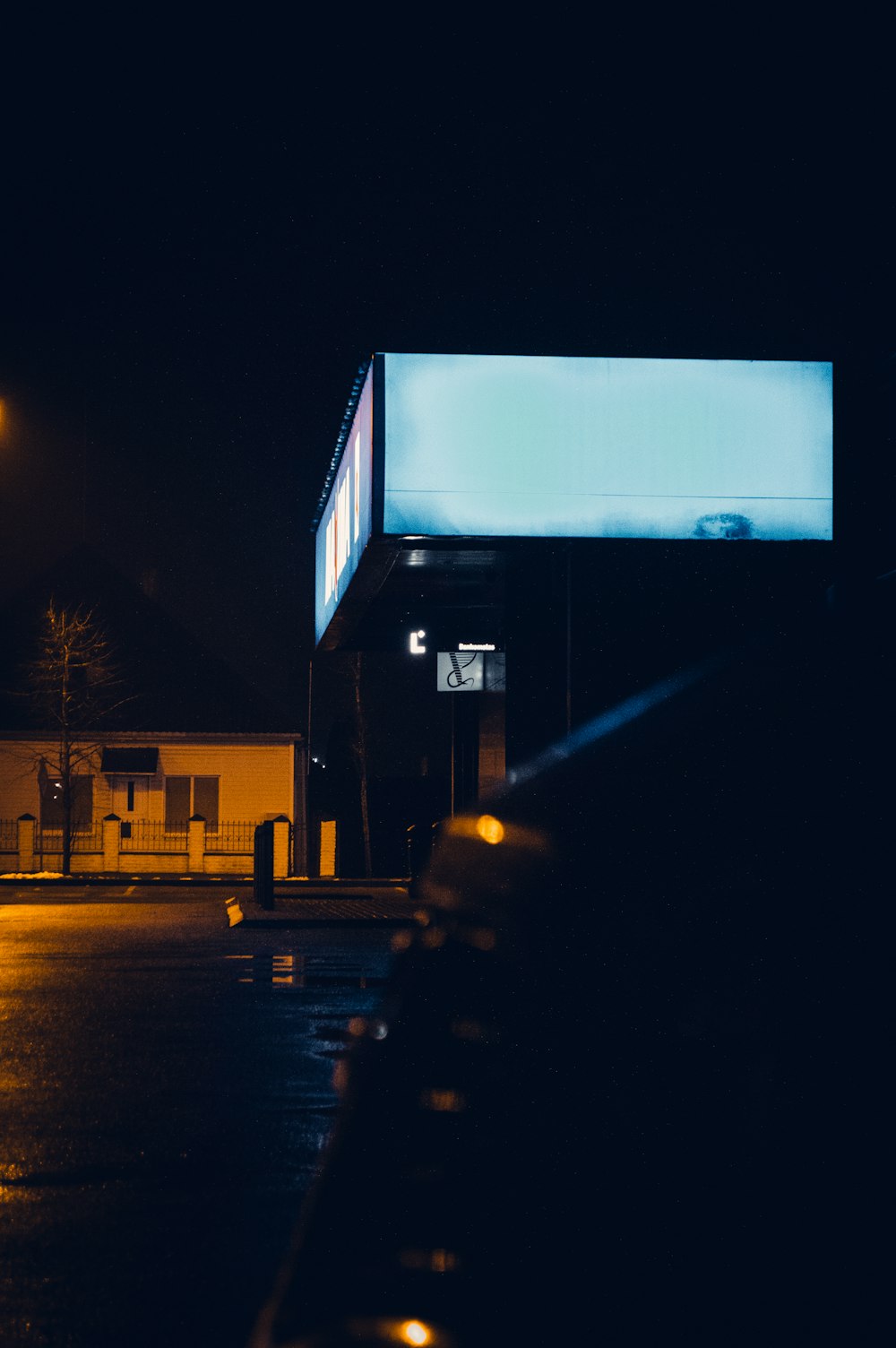an empty parking lot at night with a large screen