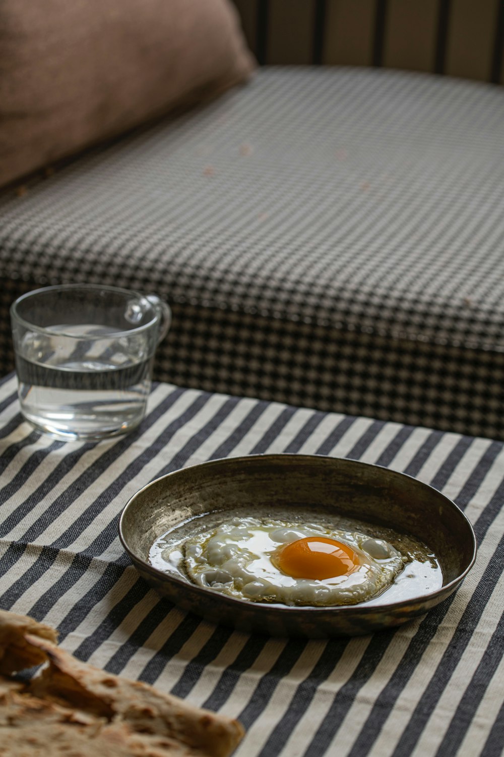 a bowl of eggs on a table next to a glass of water