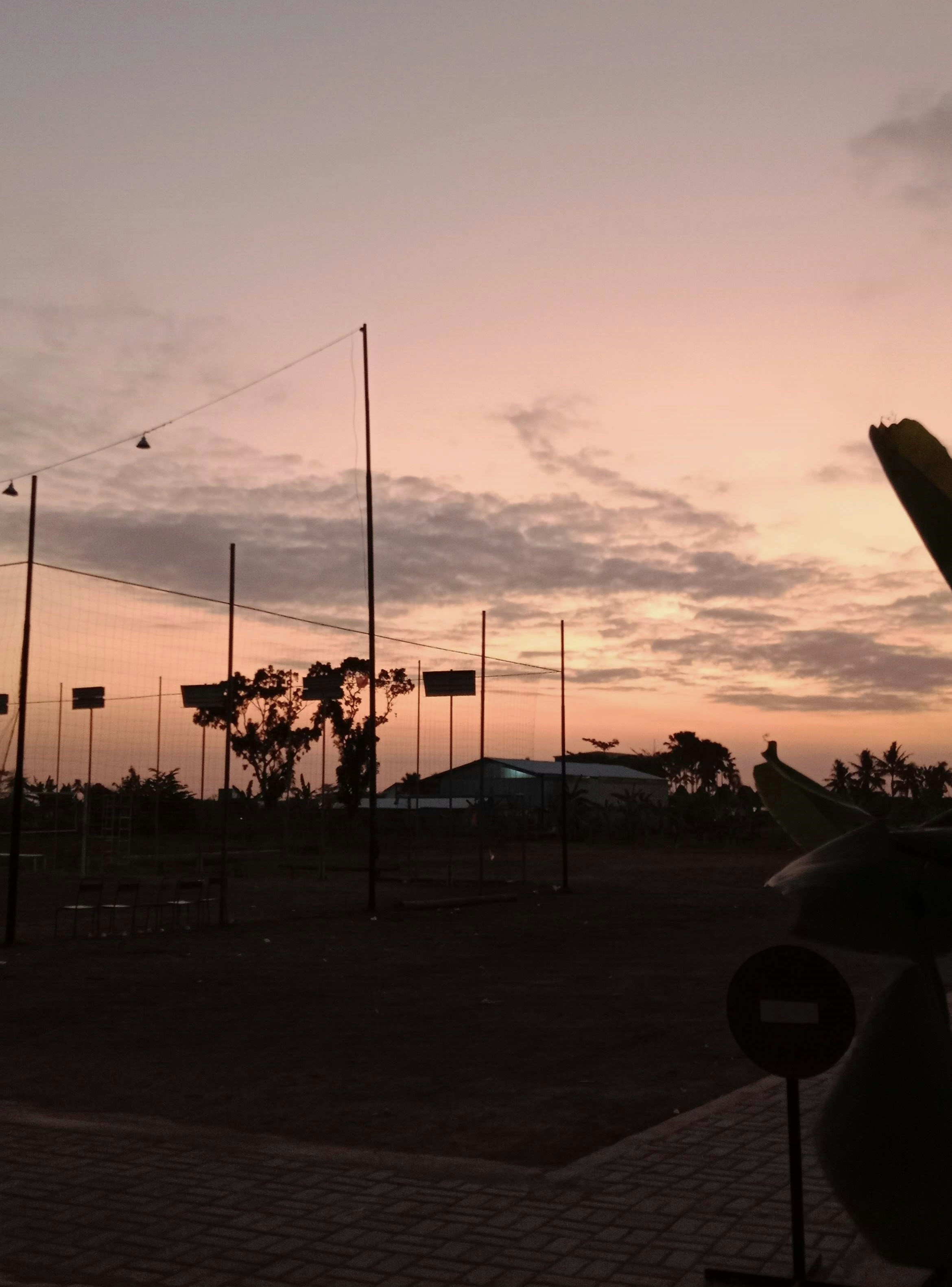 the sun is setting over a field with many flags