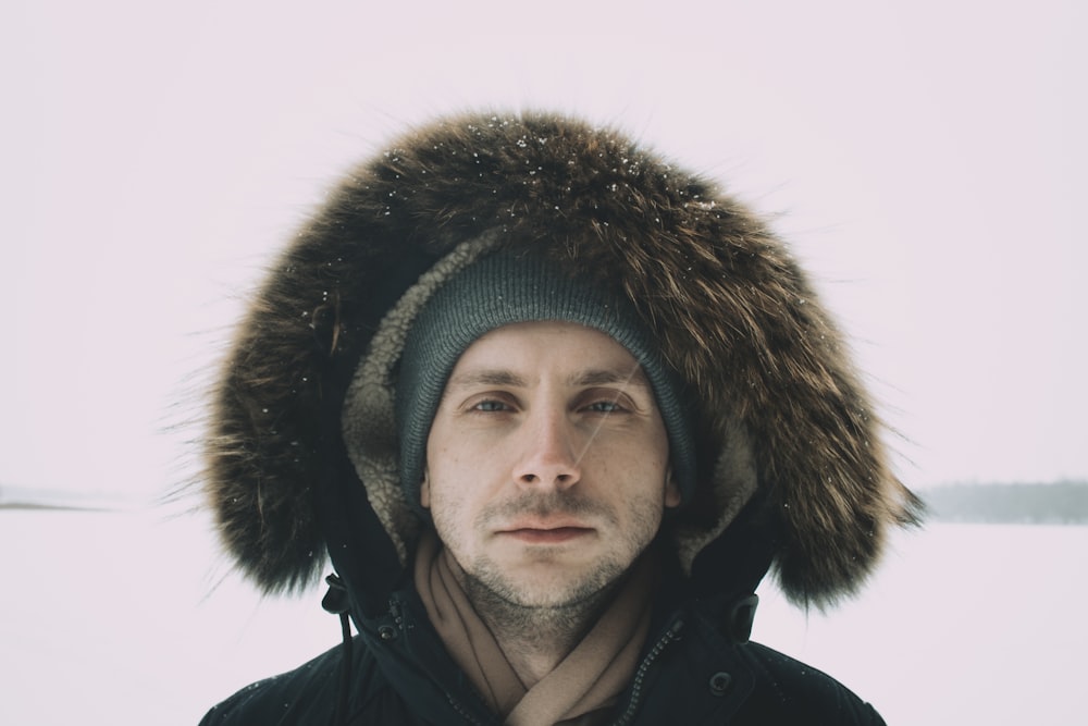 a man wearing a fur hat in the snow