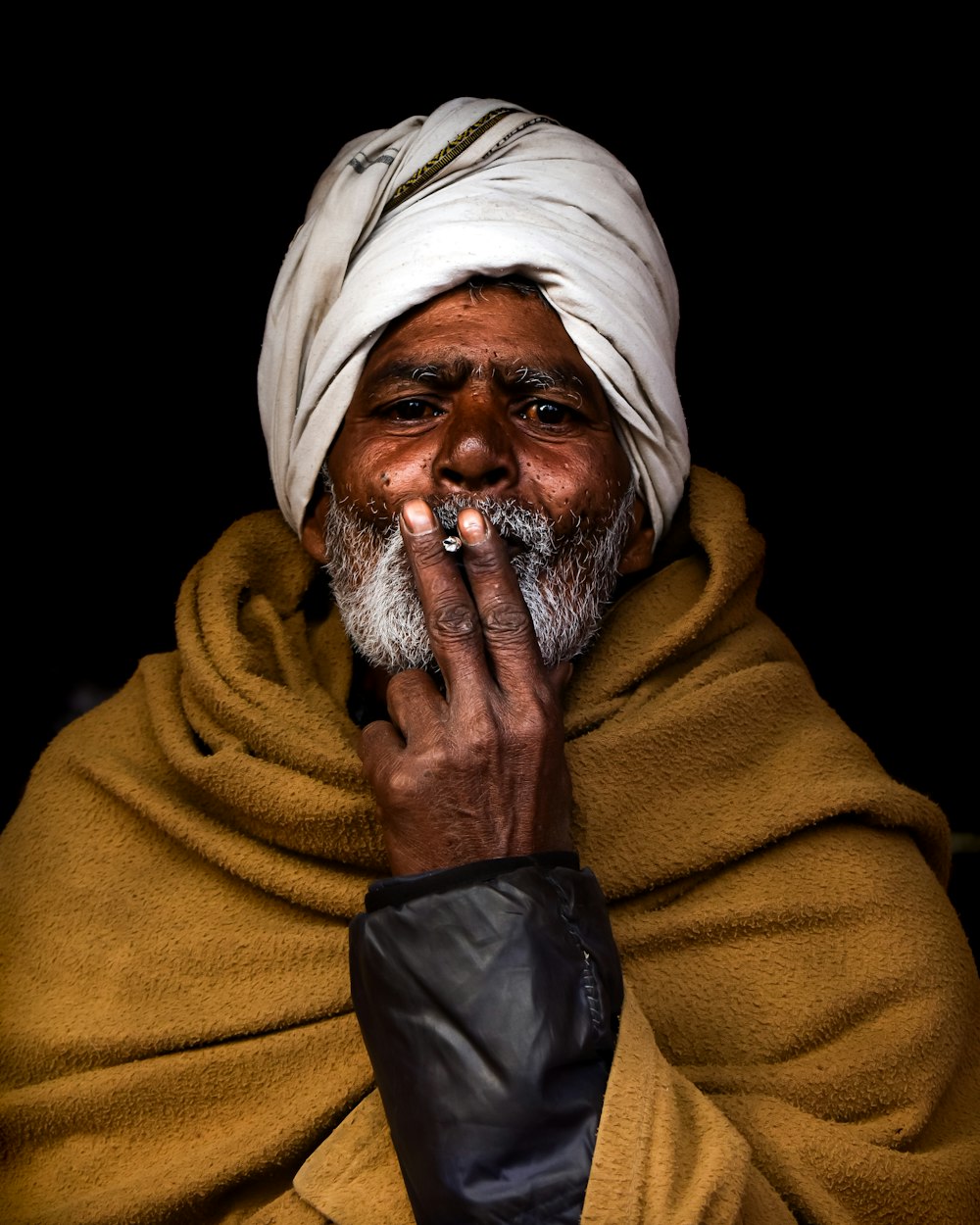 a man with a white turban smoking a cigarette