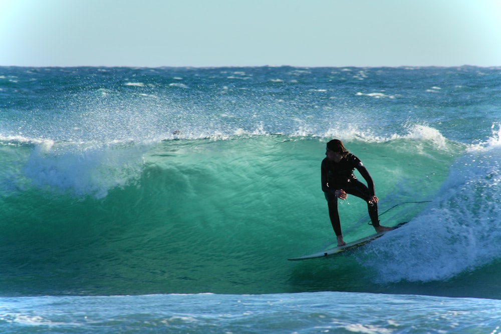 a man riding a wave on top of a surfboard