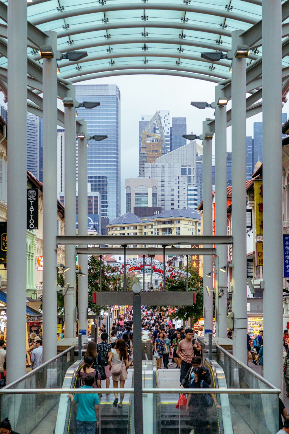 a group of people walking down a street next to tall buildings