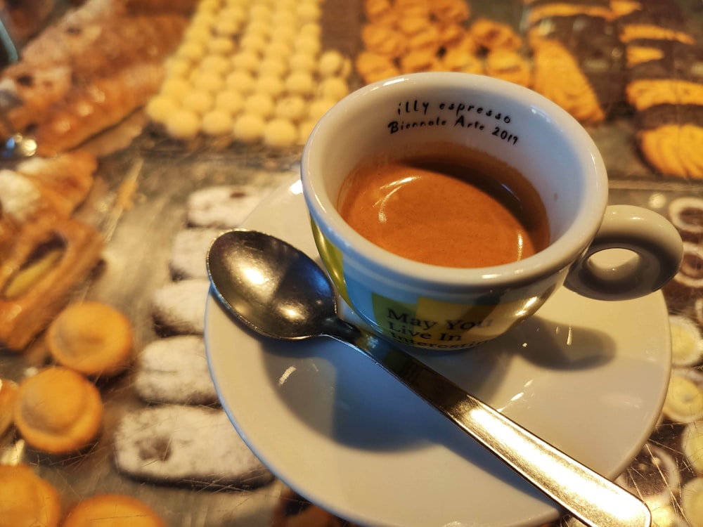 a cup of coffee on a saucer with a spoon