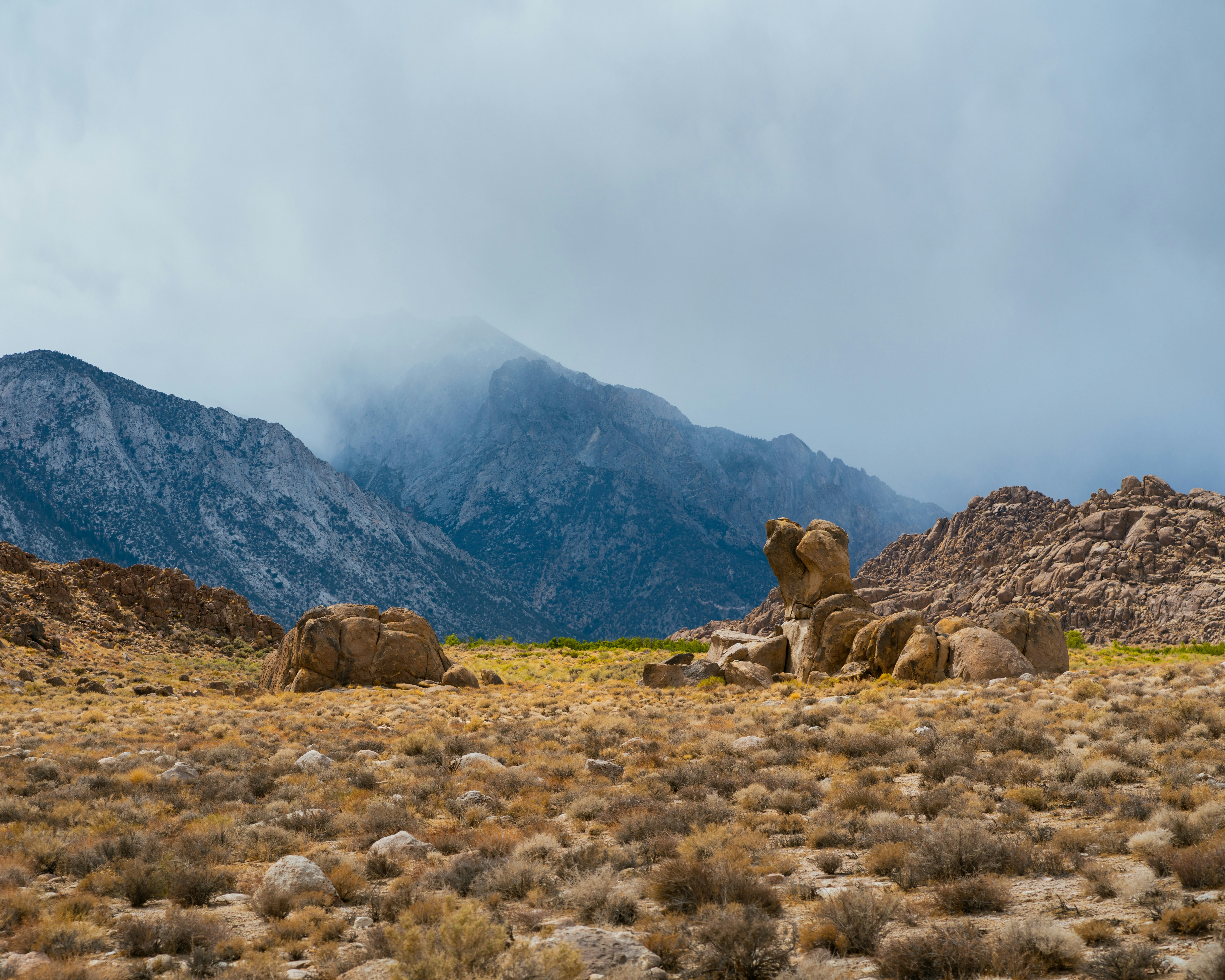 a rocky landscape with mountains in the background, Dog in the rain, Alabama Hills