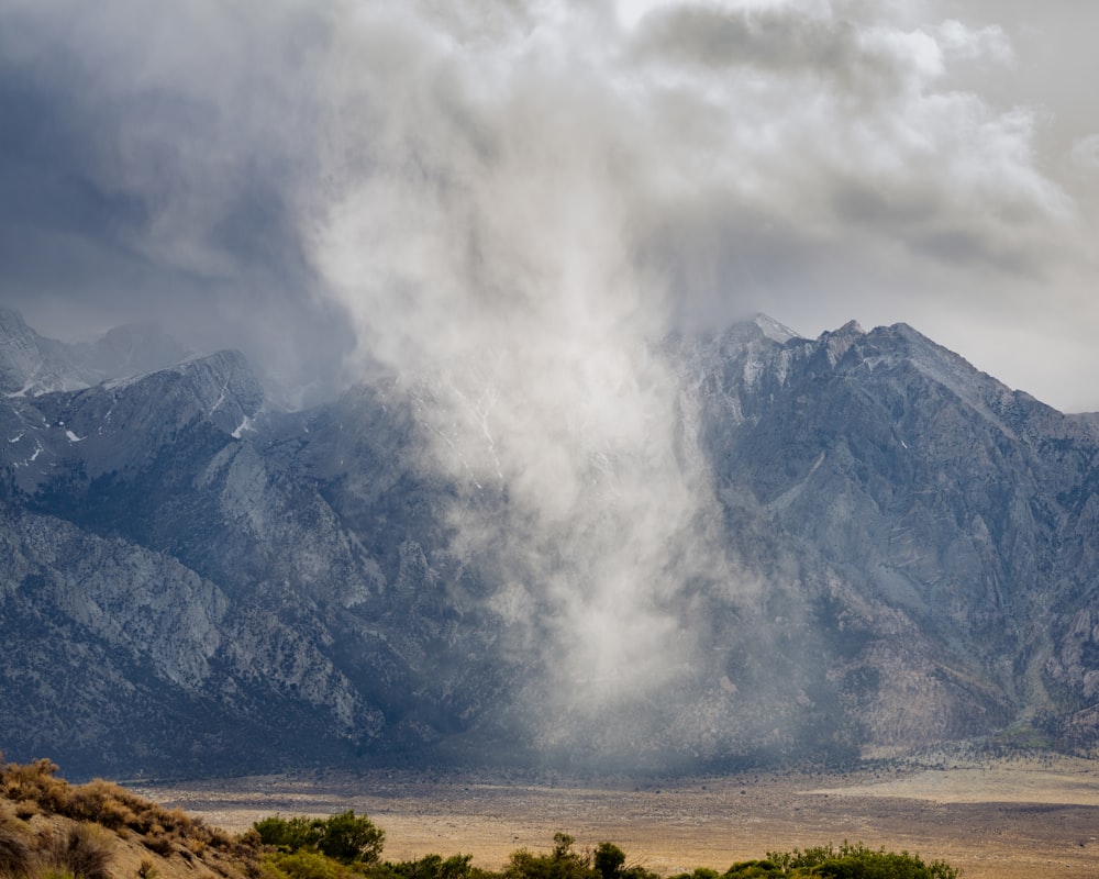 a mountain range covered in clouds in the distance