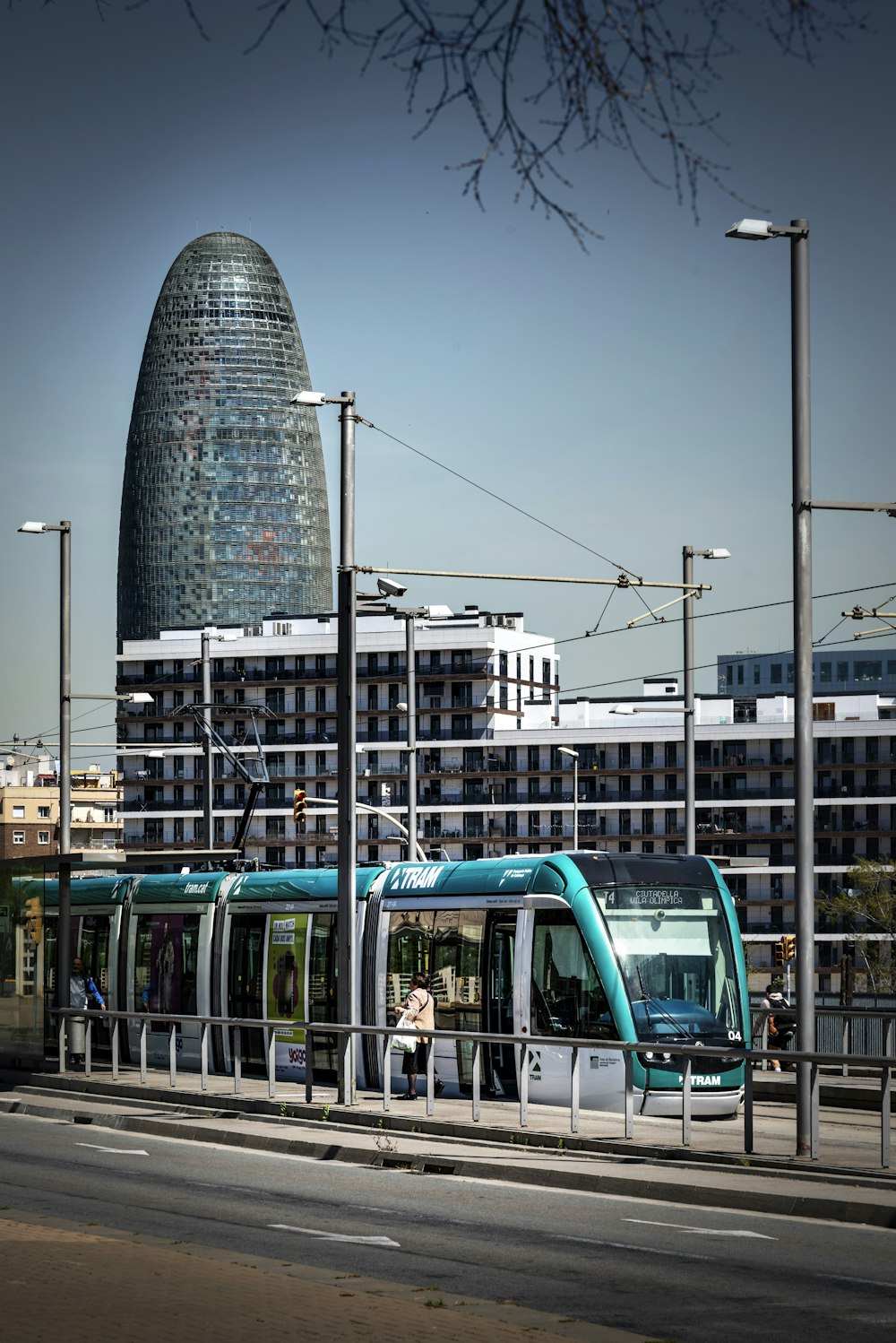 a blue and white train traveling past a tall building
