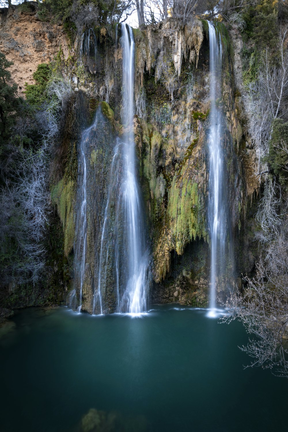 a waterfall with a body of water in front of it