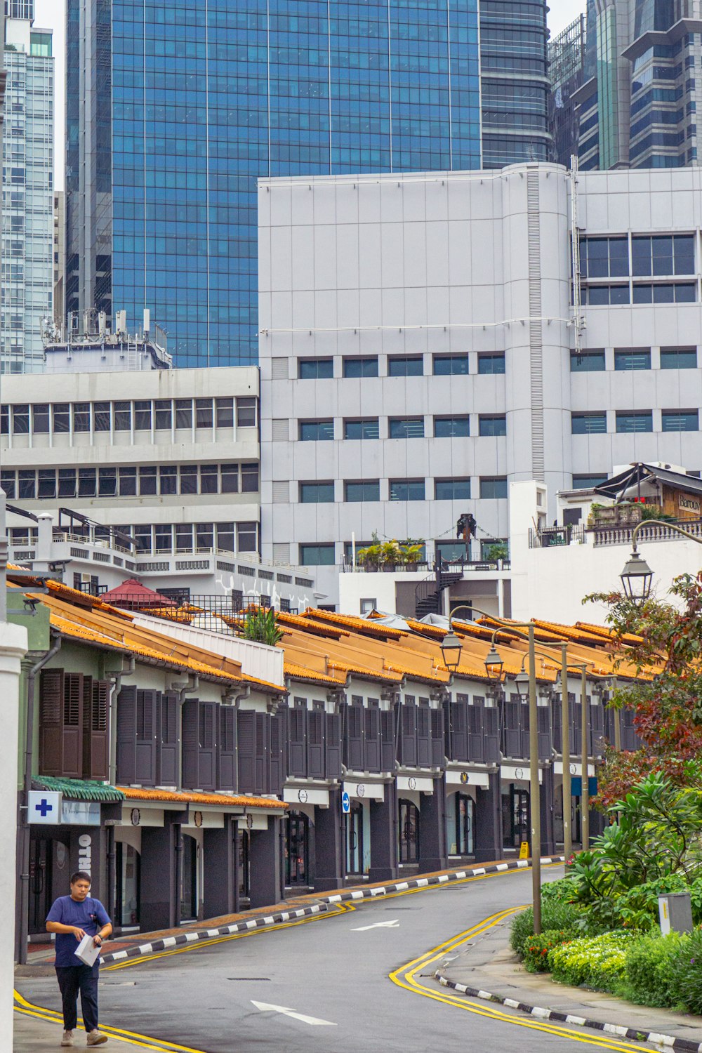 a man walking down a street next to tall buildings