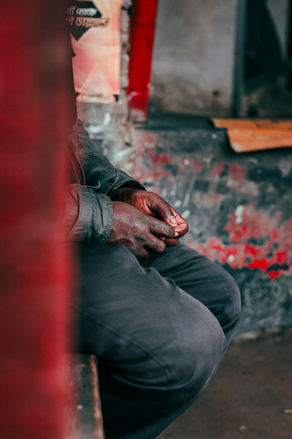 a man sitting on a bench with his hands on his knees