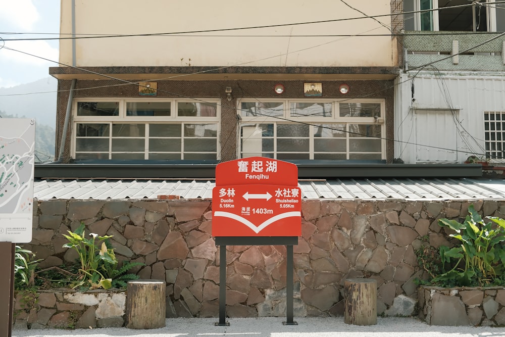 a red sign sitting in front of a building