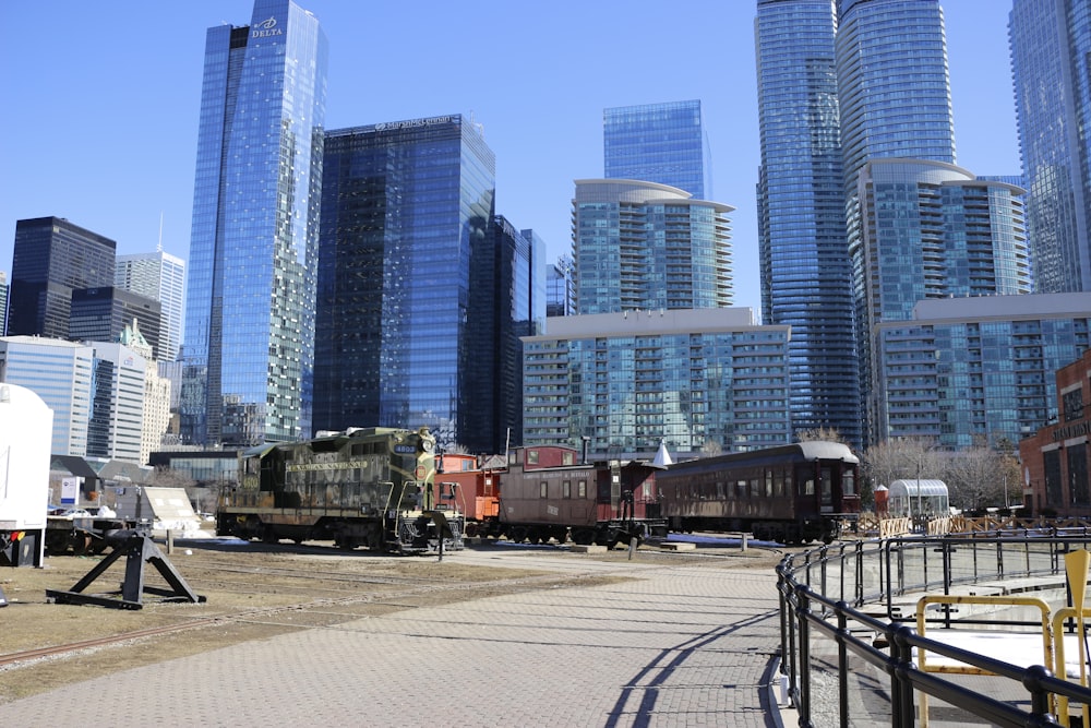 a train traveling through a city next to tall buildings