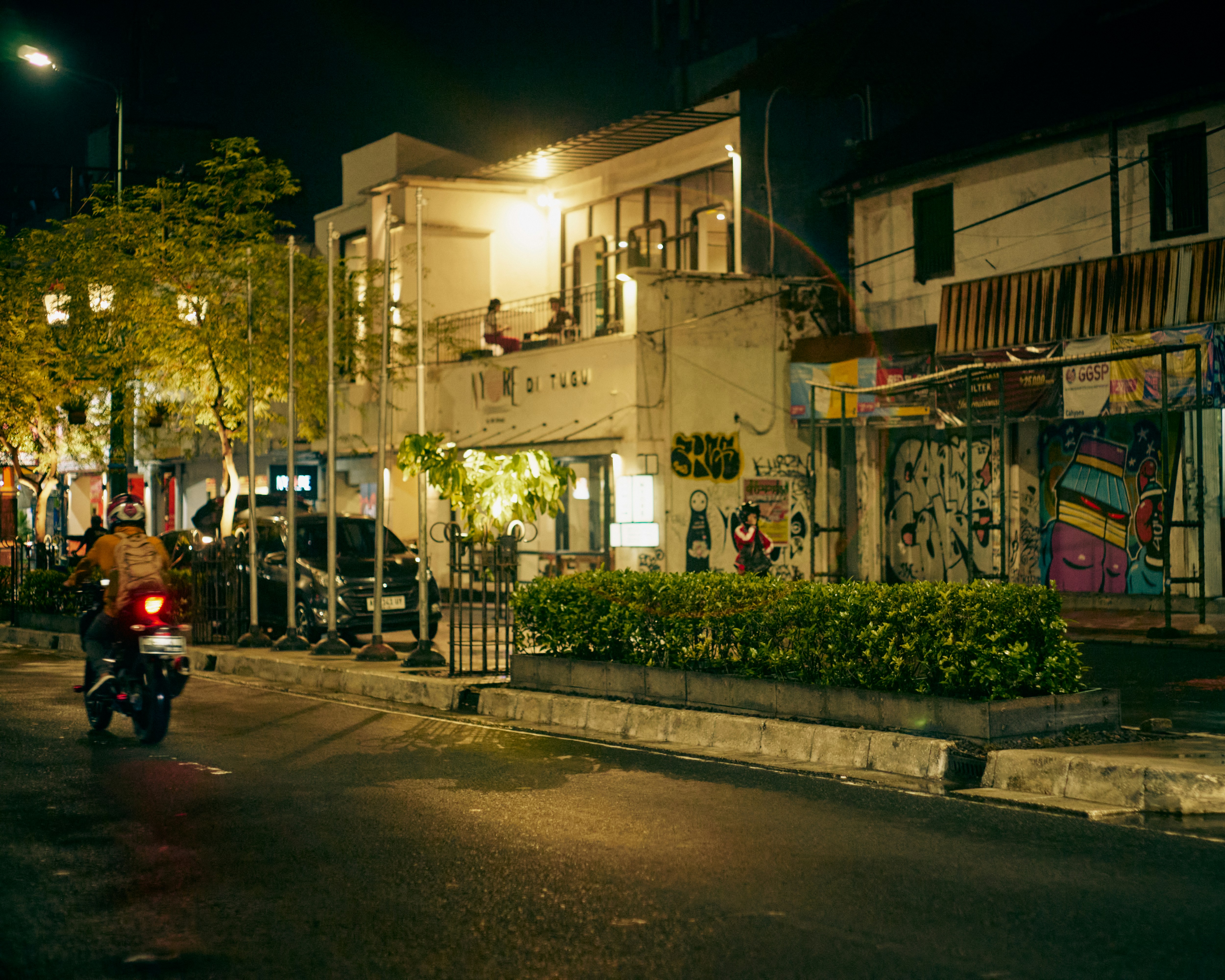 a person riding a motorcycle down a street at night