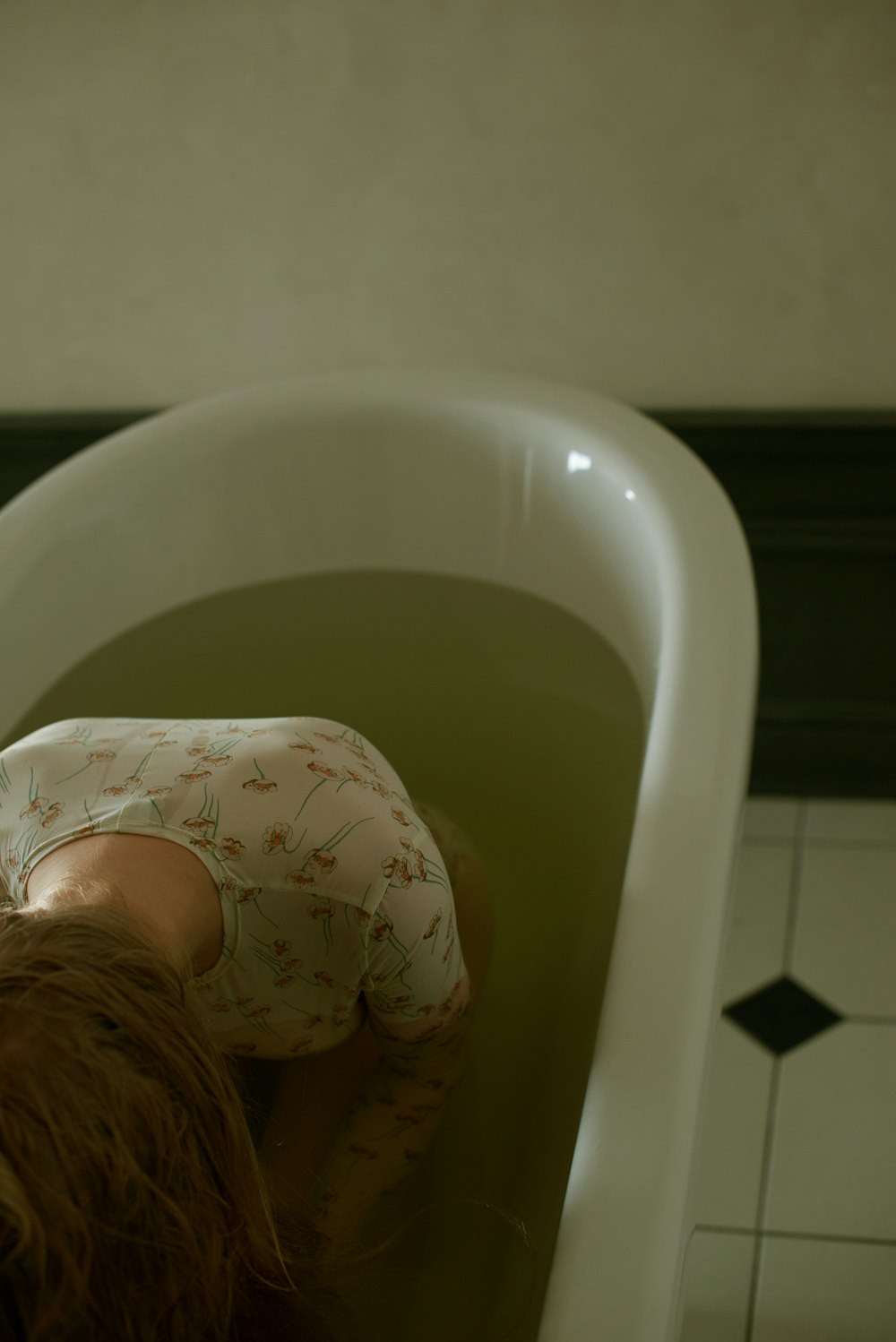 a doll laying in a bathtub with its head in the water