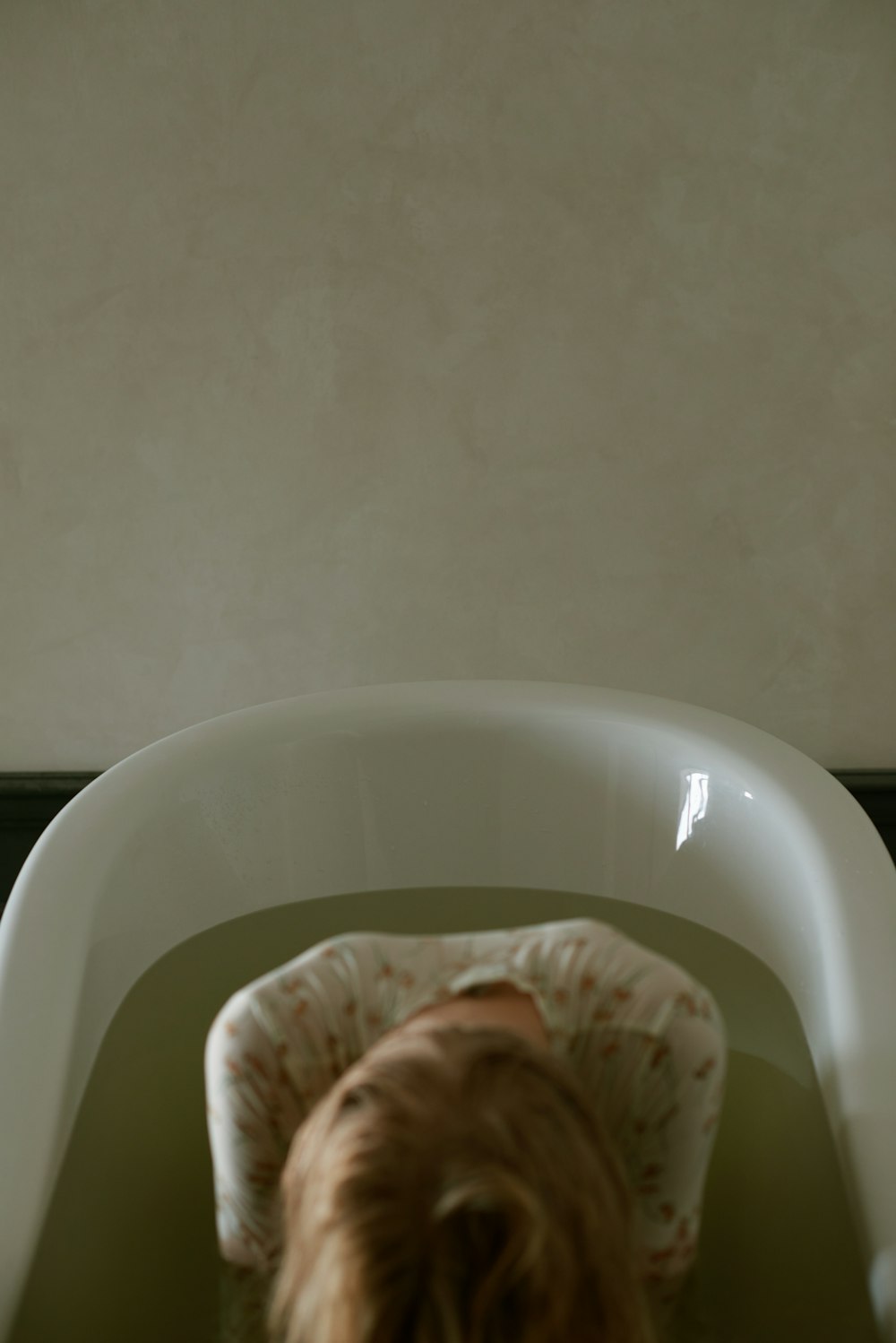 a woman in a bathtub with her head in the water