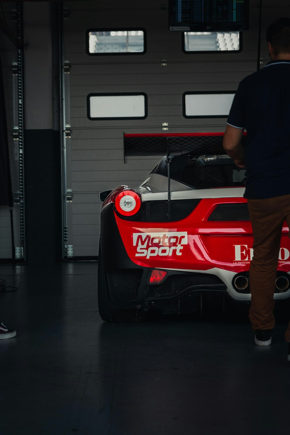 a man standing next to a red and white race car