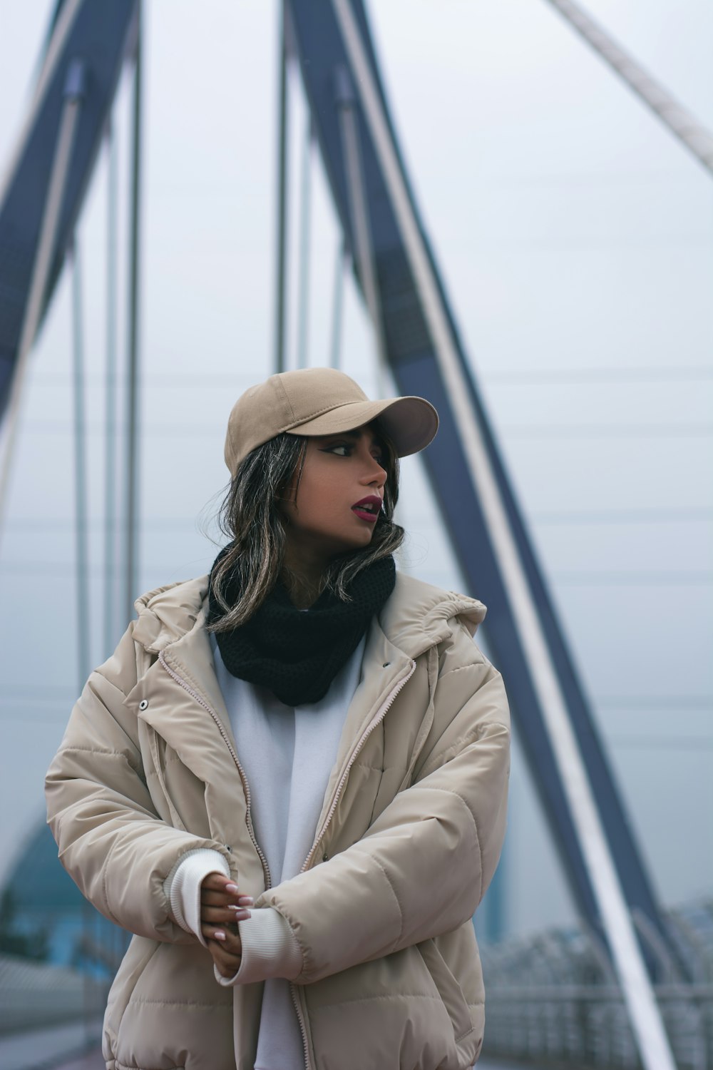 a woman standing on a bridge with her arms crossed