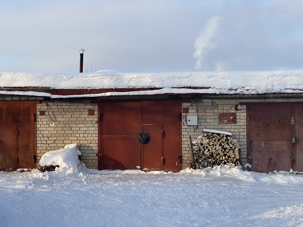 a brick building with a pile of wood in front of it