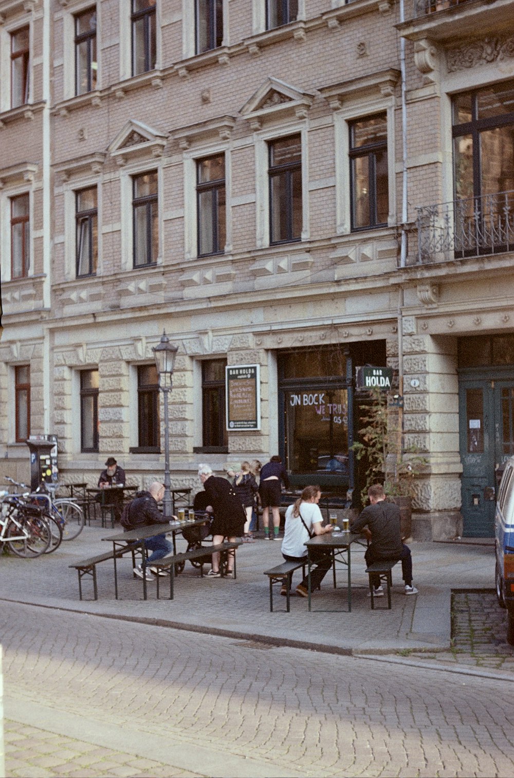 a group of people sitting at tables in front of a building