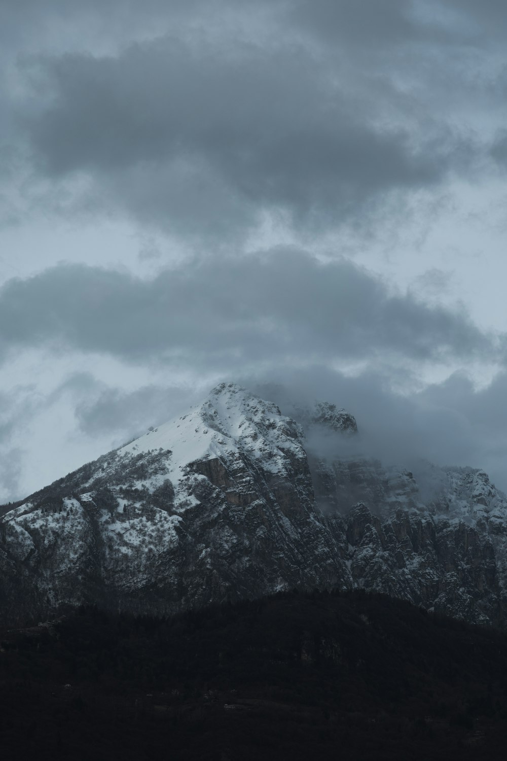 ein schneebedeckter Berg unter einem bewölkten Himmel