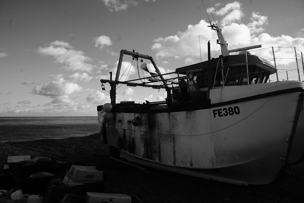 a black and white photo of a boat on the beach