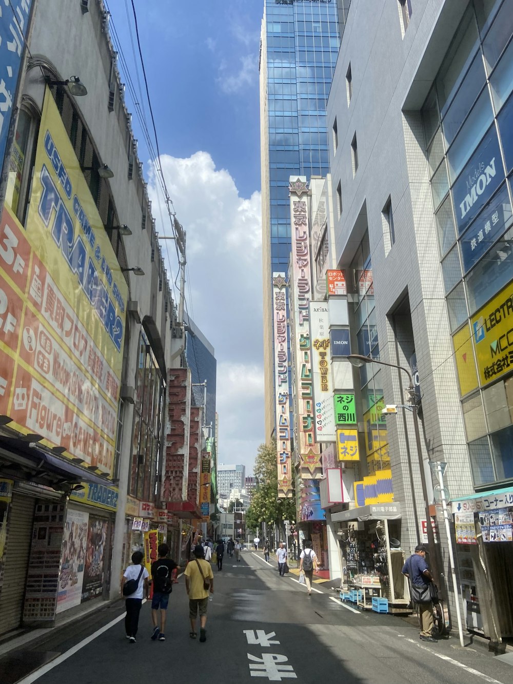 a group of people walking down a street next to tall buildings