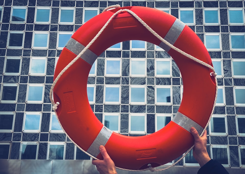 a person holding a life preserver in front of a building